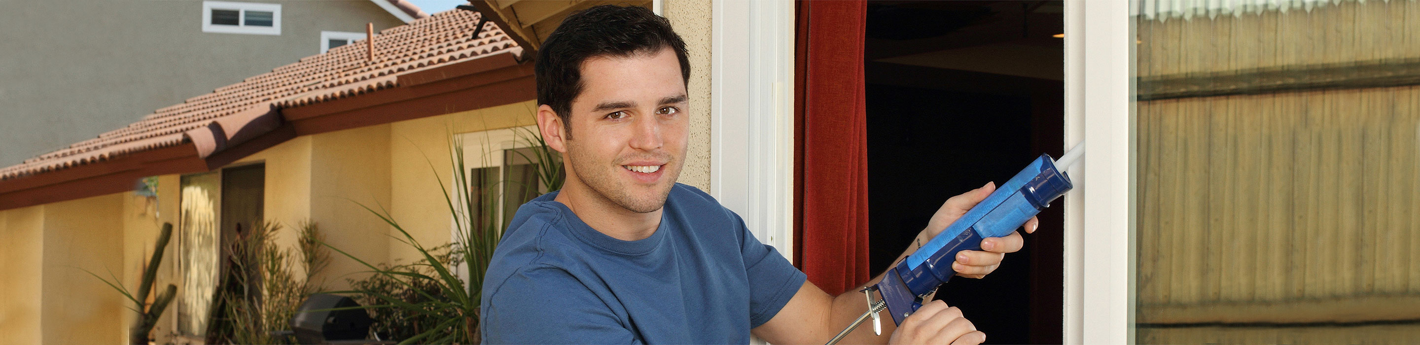 Energy-Saving-Tips Man caulking around door frames