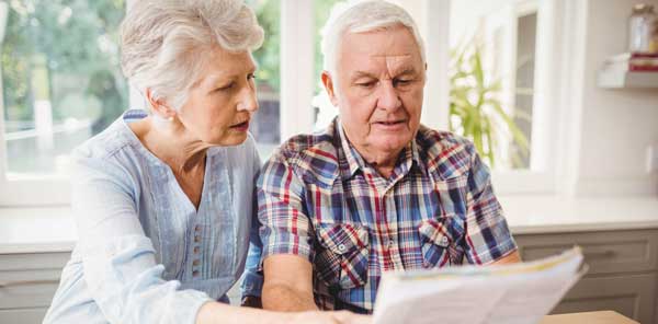 Senior couple looking at printed bill